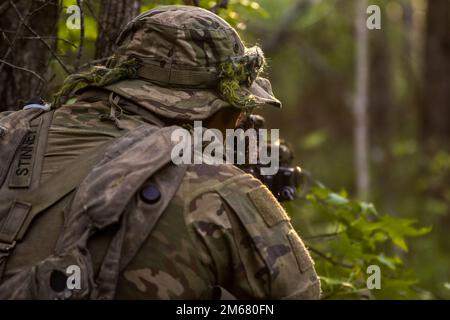 Green Beret assegnato a 3rd Special Forces Group (Airborne) stabilisce la posizione di combattimento e tira la secruità al Joint Readiness Training Center di Fort Polk, Louisiana, aprile 14. 2022. L'esercizio JRTC si è incentrato sul miglioramento della preparazione delle unità fornendo una formazione sugli armamenti altamente realistica, stressante, congiunta e combinata per le operazioni attuali e future Foto Stock