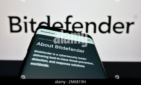 Telefono cellulare con pagina web della società rumena di cybersicurezza Bitdefender sullo schermo di fronte al logo aziendale. Messa a fuoco in alto a sinistra del display del telefono. Foto Stock