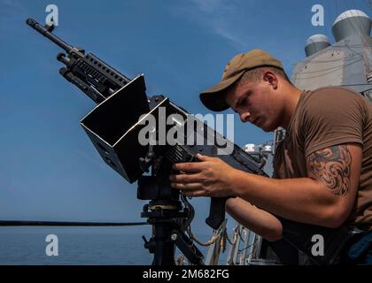 GOLFO DI OMAN (15 aprile 2022) il compagno di Gunner Seaman Clayton Slayton monta una mitragliatrice da M240B mm durante un trapano antiterrorismo a bordo del cacciatorpediniere missilistico guidato USS Gridley (DDG 101) nel Golfo di Oman, 15 aprile. Gridley viene distribuito nell'area operativa della flotta statunitense 5th per garantire la sicurezza marittima nella regione del Medio Oriente. Foto Stock