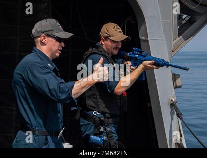 GULF OF OMAN (15 aprile 2022) Sonar Technician (Surface) 1st Classe Nathan Berens, a sinistra, insegna risposte pre-programmate al Quartermaster 1st Classe Alexander Peppel durante un'esercitazione antiterrorismo a bordo del cacciatorpediniere missilistico guidato USS Gridley (DDG 101) nel Golfo di Oman, 15 aprile. Gridley viene distribuito nell'area operativa della flotta statunitense 5th per garantire la sicurezza marittima nella regione del Medio Oriente. Foto Stock