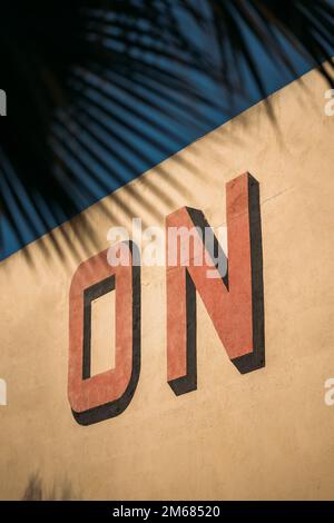 Banner creativo di strada con una parola DISEGNATA in 3D lettere rosse su sfondo giallo. Grande cartello pubblicitario con lettere volumetriche in primo piano Foto Stock