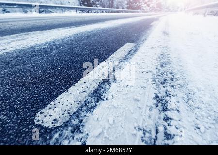 Riduzione della prospettiva della vista ravvicinata della strada asfaltata in inverno. Foto Stock