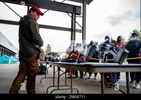 I membri del Red-tail Hawks Youth Program imparano a conoscere le armi da combattimento durante l'evento Aviation Inspiration and Mentorship (AIM) Wing alla base militare Lewis-McChord, Washington, 16 aprile 2022. AIM Wing è un programma di sensibilizzazione della comunità con la missione di informare, influenzare e ispirare la prossima generazione di aviatori dell'aeronautica militare. Foto Stock