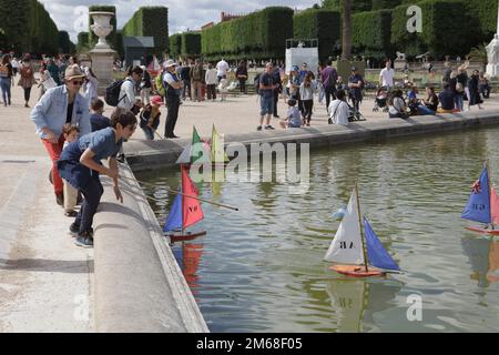 I bambini navigano in motoscafi sul Grand Bassin al Jardin de Luxembourg di Parigi in una giornata estiva Foto Stock