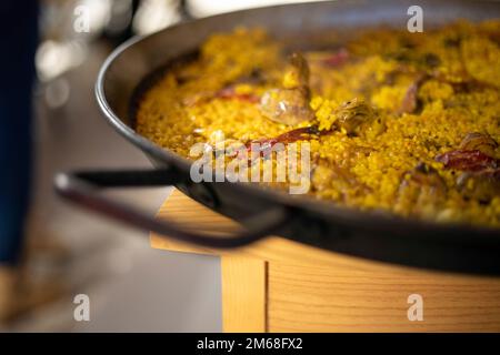 primo piano di una paellera con una tipica paella spagnola fatta in casa con pollo e pepe rosso Foto Stock