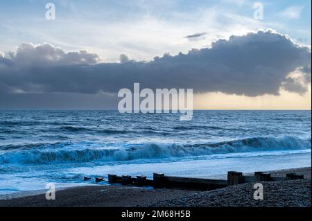 Nuvole drammatiche sul mare e sulla spiaggia a Bexhill-on-Sea, Regno Unito Foto Stock