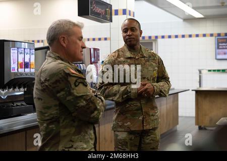 STATI UNITI Il comando dell’Esercito europeo e africano Sgt. Major Jeremiah E. Inman parla con il comando Sgt. Major James R. Holmes III, il comandante del 35th dell’Accademia ufficiale non commissionata dell’Esercito del 7th, in una sala da pranzo a Grafenwoehr, Germania, 19 aprile 2022. Inman ha visitato la NCO Academy per pranzare con sei soldati attualmente iscritti al Basic Leaders Course. Foto Stock