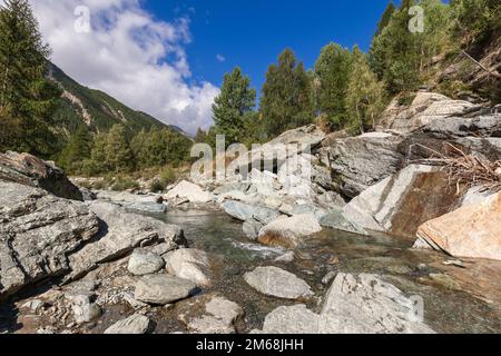 Torrente Grand Eyvia nel Parco Nazionale del Gran Paradiso sotto il cielo azzurro con nuvole bianche Foto Stock