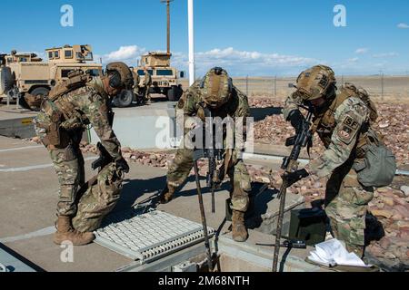 Tre membri della forza di risposta tattica del 341st Missile Security Operations Squadron assicurano una struttura di lancio durante un esercizio di addestramento il 19 aprile 2022, vicino alla base dell'aeronautica militare di Malmstrom, Month. Il ruolo di TRF nell'esercizio era quello di fornire supporto a 841st difensori dello Squadrone delle forze di sicurezza missilistiche già presenti in loco. L’esercizio è stato concepito per testare il lavoro di squadra di tutto il personale e la conoscenza delle politiche e delle procedure. Foto Stock