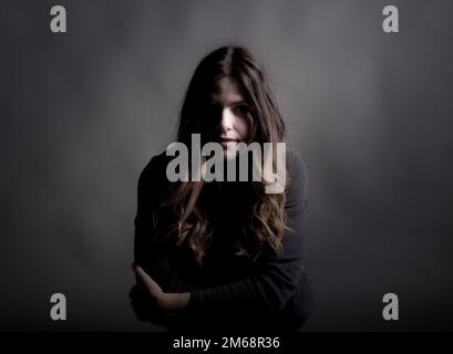 Un bel ritratto donna studio su sfondo scuro Foto Stock