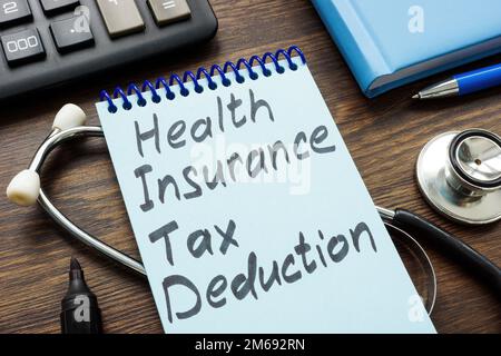 Apri notebook con iscrizione assicurazione sanitaria deduzione fiscale. Foto Stock