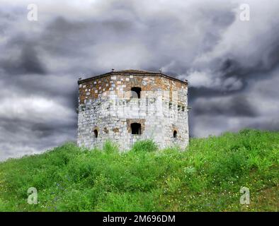 Vecchia torre di pietra sul cielo nuvoloso Foto Stock