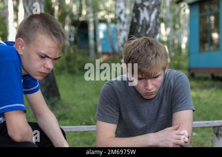 Regione di Chelyabinsk - 12 luglio 2019. Due ragazzi si appoggiarono sul barbecue. Foto Stock