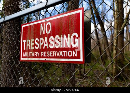 Un cartello di non trasgressione appende lungo la recinzione perimetrale del Connecticut Army National Guard Training Center East Haven Rifle Range, East Haven, Connecticut, 20 aprile 2022. È illegale, in base al Codice degli Stati Uniti titolo 18 Sezione 1382, trasgressione agli Stati Uniti Installazioni militari per includere le installazioni del Dipartimento militare del Connecticut. Foto Stock