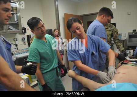 Grady Health System Interim Trauma Medical Director Dr. Jonathan Nguyen (scrub verdi) orologi Martin Army Community Hospital laurea residente Capt. Samantha Green inserire un tubo toracico durante la Famiglia Medicina Residency Experience (FMRx), aprile 20. Nella foto, da sinistra a destra, sono raffigurati anche i sottotitoli. Patrick Campbell e Kyle Warren. Foto Stock