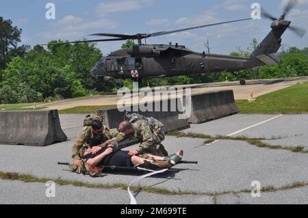 Martin Army Community Hospital Family Medicine Residency Program Chief Resident Capt. Patrick Campbell (sinistra) e il Capt. Timothy binkley (destra) evacuano medicalmente Adam Haussman come parte della Family Medicine Residency Experience (FMRx), aprile 21. Foto Stock