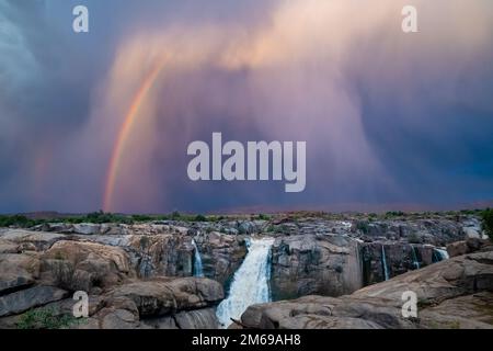 Arcobaleno e nuvole tempesta sulle cascate di Augrabies. Augrabies Falls National Park, Sudafrica. Foto Stock