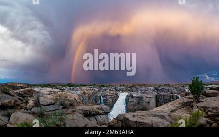 Arcobaleno e nuvole tempesta sulle cascate di Augrabies. Augrabies Falls National Park, Sudafrica. Foto Stock