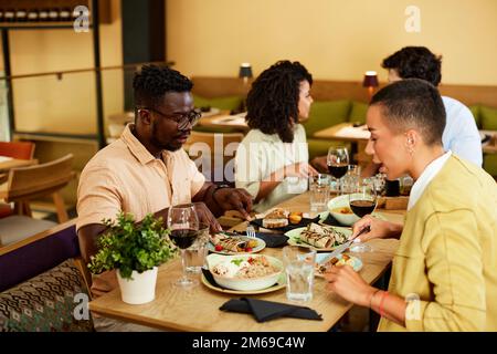 Gli amici cenano in un ristorante. Foto Stock