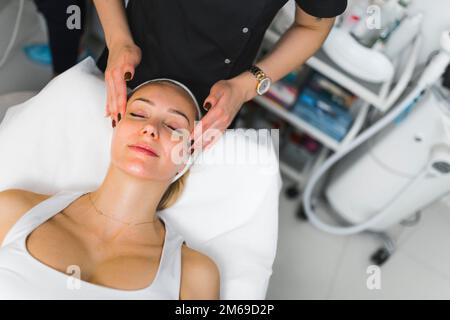 Scatto ad angolo alto di una donna che ha le sue tempie massaggiate mentre sdraiato con la sua eyesy chiusa. Concetto di bellezza. Foto di alta qualità Foto Stock