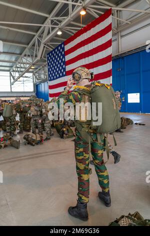 Un paracadutista belga assegnato al 2nd° Comando Battaglione, reggimento delle operazioni speciali, indossa il casco mentre si prepara per un salto accanto ai Paracadutisti francesi assegnati al 8th° Reggimento dei Paracadutisti della Fanteria Marina, 11th° Brigata del Paracadute, durante l'operazione Nemesis, sulla base aerea di Chièvres, Belgio, 20 aprile 2022. Operations Nemesis è stato un esercizio congiunto di più giorni tra le forze belghe e francesi, che si sono schierate dalla base aerea di Chièvres per eseguire missioni in più località del paese. Foto Stock