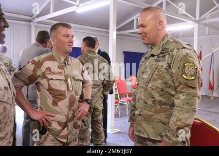 Brig. Il generale Nick Ducich, direttore del gruppo consultivo militare, Combined Joint Task Force-inerente Resolve (CJTF-OIR), destra, Rolf Helland, CJTF – OIR Norvegia Senior National Representative, ha lasciato, tiene una discussione durante l'evento della Giornata degli Ambasciatori presso la base operativa di Union III a Baghdad, in Iraq, il 21 aprile 2022. Durante l'evento ospitato dal CJTF-OIR, i rappresentanti di oltre 25 paesi della coalizione hanno discusso la missione CJTF-OIR e gli ampi sforzi per affrontare le sfide durature della sicurezza e della stabilità regionale. Foto Stock