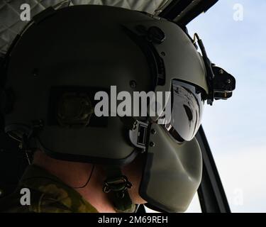 Il Senior Airman Robert Knopes, 54th Helicopter Squadron UH-1N Huey Flight Engineer, guarda all'esterno su un impianto di lancio missilistico il 21 aprile 2022, nel North Dakota. L'equipaggio di 54th HS ha controllato varie strutture di lancio dei missili per cercare eventuali danni dovuti ai quattro piedi di neve consegnati a Minot e nei dintorni da Blizzard Haley. Foto Stock