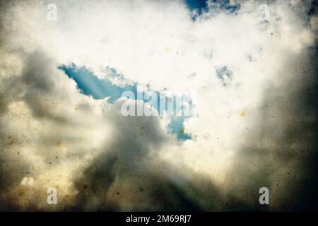 Nuvole e un cielo blu con raggi solari che brillano, utile come elemento di sfondo nei lavori di progettazione. Foto Stock