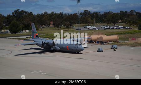 NEGLI STATI UNITI Air Force C-130J Super Hercules MAFFS (Modular Airborne Firefighting System) l'aereo assegnato alla 146th Airlift Wing siede sulla linea di volo di fronte ai nuovi pozzi MAFFS presso la Channel Islands Air National Guard Station, Port Hueneme, California 21 aprile 2022. I nuovi serbatoi a terra ignifughi hanno aumentato la capacità di stoccaggio di cinque volte, passando da una capacità di 10.000 galloni a 50.000 galloni, per ospitare più aerei MAFFS e gli Stati Uniti Le autocisterne aeree molto grandi (VLAT) di Forest Service con soluzione antifuoco e acqua. Foto Stock