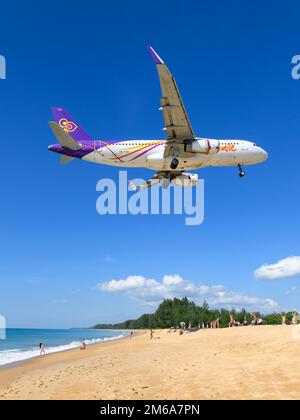 Aereo della compagnia aerea Thai Smile Airbus A320 sopra mai Khao Beach dall'Aeroporto di Phuket. Aereo A320 di Thai Smile Airways che sorvola la spiaggia turistica. Foto Stock