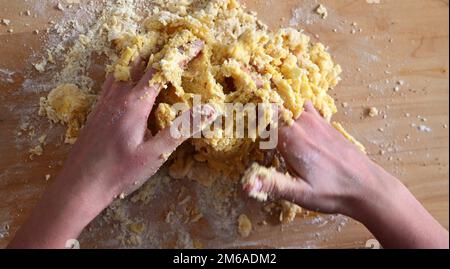 giovani mani caucasiche che impastano pasta frolla per torta dolce Foto Stock