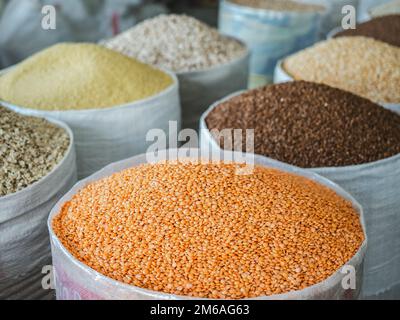 Borse e ciotole con spezie profumate giacenti sul mercato in una giornata di sole e limpide. Primo piano, all'aperto, nessuna persona. Concetto di cibo gustoso e sano Foto Stock