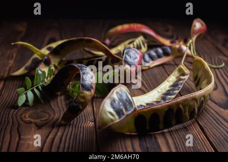 Semi di acacia su sfondo di legno. Primo piano. Foto Stock