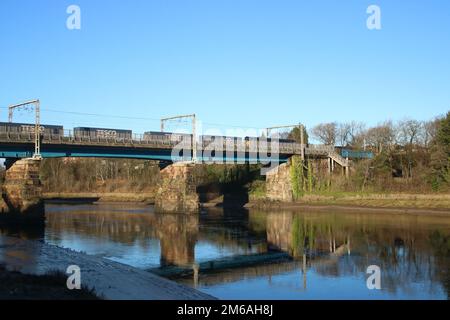 Container (Tesco train) trainato da Direct Rail Services classe 66 diesel loco su WCML sul Carlisle Bridge River Lune a Lancaster il 2nd gennaio 2023. Foto Stock