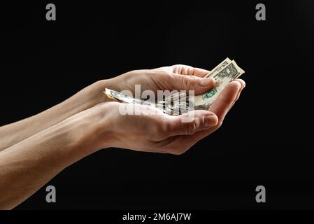 Aiuti negli Stati Uniti. un povero che non tiene molto soldi, dollari. Il concetto di aiutare i senzatetto e le persone svantaggiate Foto Stock