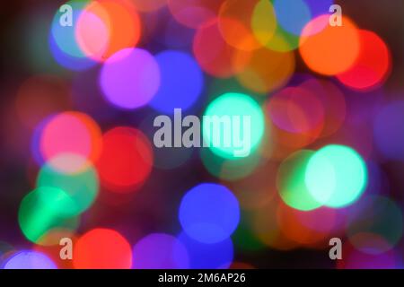 Luci sfocate colorate che si sovrappongono nel motivo di sfondo con punti di luce bokeh Foto Stock