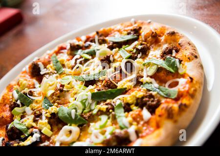 Pizza con carne e curry. Pizza napoletana a base di manzo al curry speziato. Ricetta italiana. Foto Stock