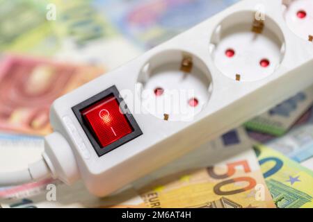 Presa multipla commutabile, banconote in euro, immagine simbolica costi energetici, costi elettrici, risparmio energetico Foto Stock