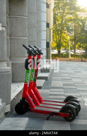 Scooter elettrici del marchio Lime parcheggiati vicino all'edificio degli uffici a Bucarest, Romania, il 4 ottobre 2021 Foto Stock