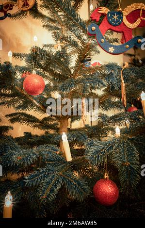 Palline rosse di Natale su un albero di Natale e un cavallo a dondolo fatto di feltro con le luci dell'albero di Natale, Hannover, bassa Sassonia, Germania Foto Stock