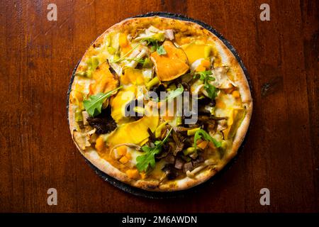 Pizza con rucola, zucca, funghi e mozzarella. Foto Stock