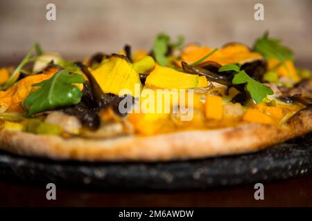 Pizza con rucola, zucca, funghi e mozzarella. Foto Stock