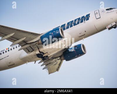 Bucarest, Romania - Agosto 2022: Un velivolo TAROM BOEING 737-700 che vola contro il cielo blu chiaro Foto Stock