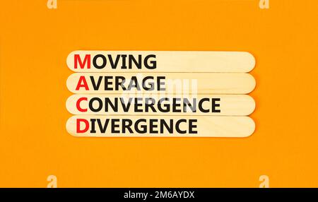 Simbolo MACD. Concetto di parole MACD Moving Average Convergence divergenza su bastone di legno su bellissimo sfondo arancione. Business MACD Moving Average con Foto Stock