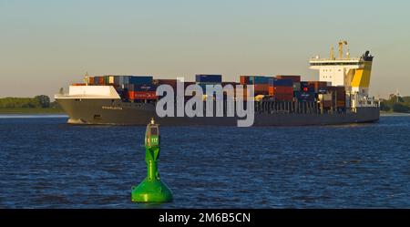 Nave portacontainer sull'Elba vicino a Luehe alla luce della sera, boa del fairway, distretto di Stade, Germania Foto Stock