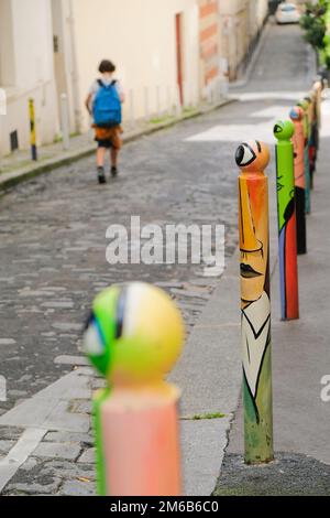 Parigi, Francia - serie di paletti decorati a Montmartre. Opere d'arte hip sui pali della strada. Giorno paesaggio urbano di strada parigina. Sfondo verticale. Foto Stock