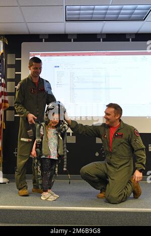 STATI UNITI Kevin 'Sajaca' Donovan e il capitano Benjamin 'King' Fischer, piloti con il 131st Fighter Squadron, aiutano un membro del Southwick Massachusetts Boy Scout Troop 338 e i membri della famiglia di accompagnamento provare l'attrezzatura di volo durante un tour della 104th Fighter Wing 22 aprile 2022, Presso la base della Guardia Nazionale dell'Aeronautica di Barnes, Massachusetts. I tour offrono l'opportunità di rafforzare le relazioni, mettendo in evidenza la missione unica e le abilità degli anni '104FW per la comunità e i partner della comunità circostante. Foto Stock