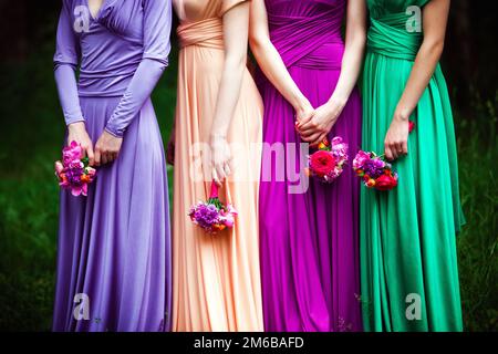 Bridesmaids in abiti colorati con bouquet di f Foto Stock