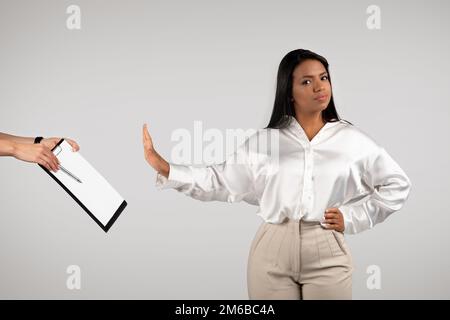 Fiducioso arrabbiato giovane afroamericana business donna facendo un gesto di stop con mano per contratto Foto Stock