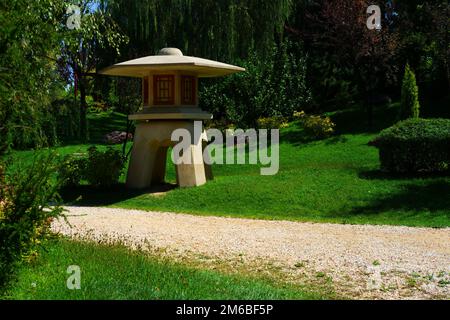 Torre di avvistamento in cemento in miniatura presso il parco vicino al sentiero tra alberi ed erba in una giornata di sole estate Foto Stock